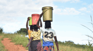 Frauen transportieren Wasserbeh&auml;lter &uuml;ber einen Feldweg in Malawi