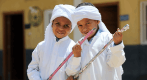 kinder-mit-schulmaterial-oberaegypten Zwei Kinder in traditioneller Kleidung freuen sich über Schulmaterial an einer AUEED-Schule in Oberägypten.