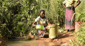 Frau entnimmt Wasser aus einem Bach im Dorf Chiguliro